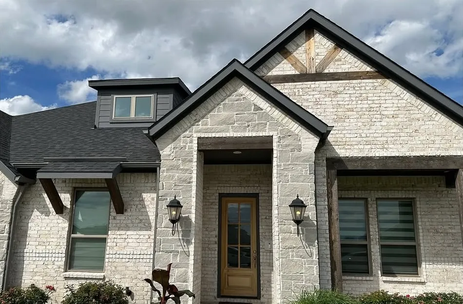 Before: the front of the home with weathered, light wood beams and front door
